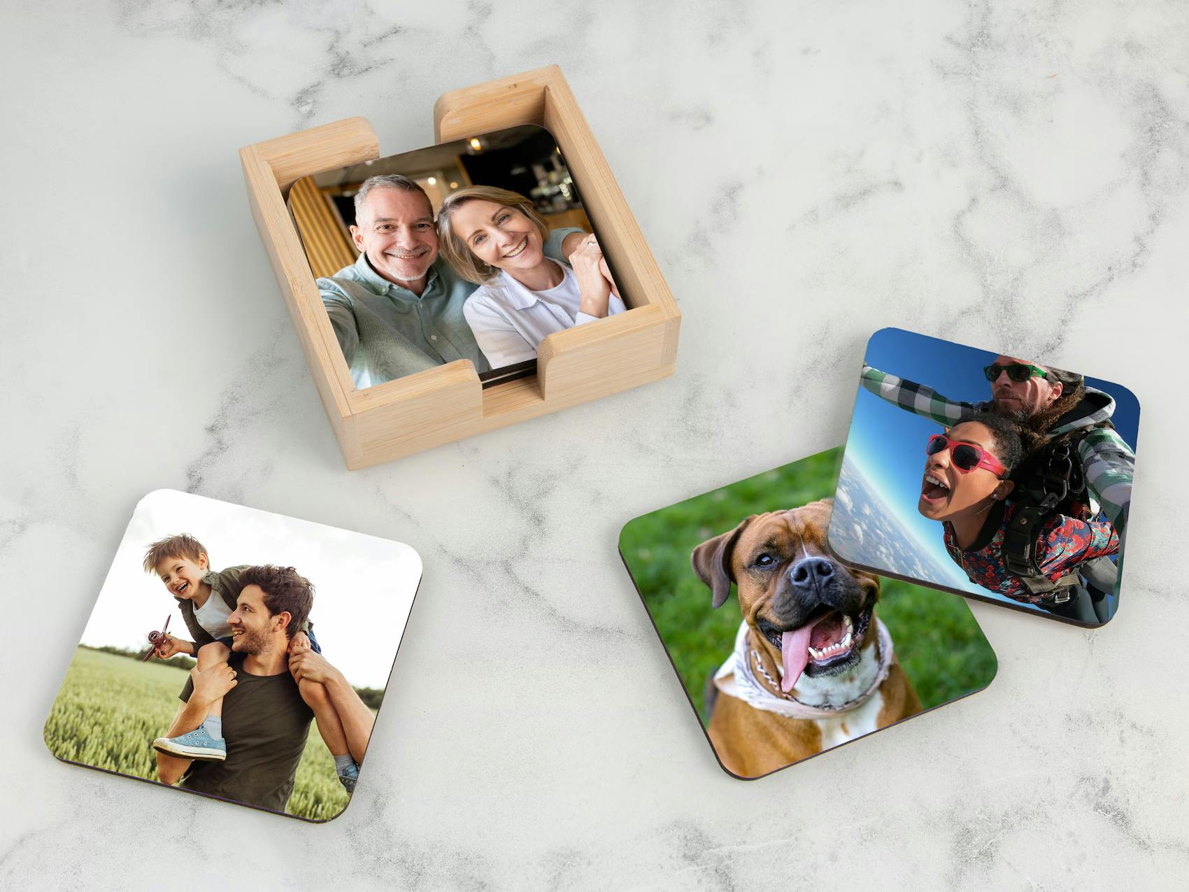 Et sæt personlige glasunderlag med forskellige printede fotos, der ligger dekorativt på et bord