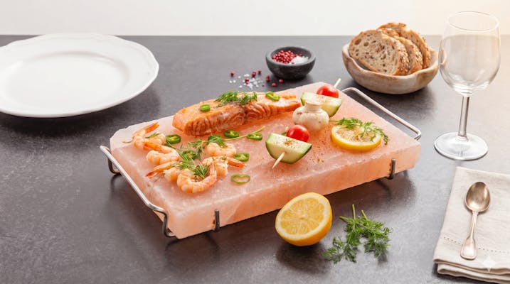 Grillad lax och räkor serverade på en salthäll av rosa himalayasalt – en unik inflyttningspresent för matälska