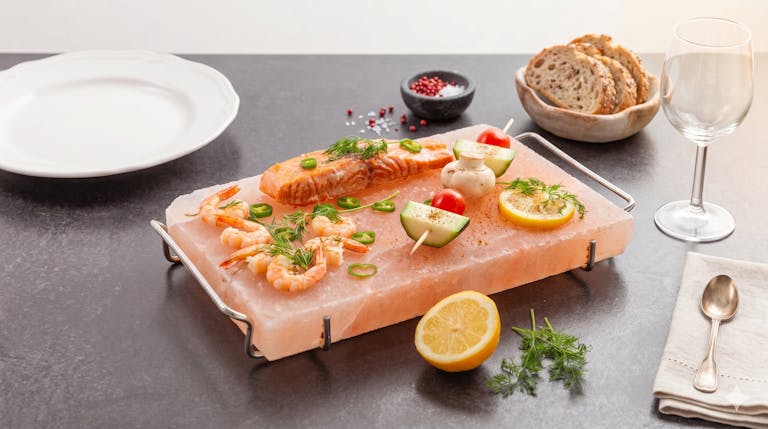 Grillad lax och räkor serverade på en salthäll av rosa himalayasalt – en unik inflyttningspresent för matälska