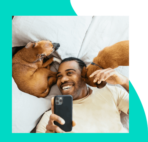 Male in bed cuddling with two dogs