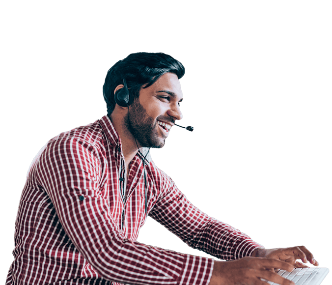 Man on a computer with a headset smiling