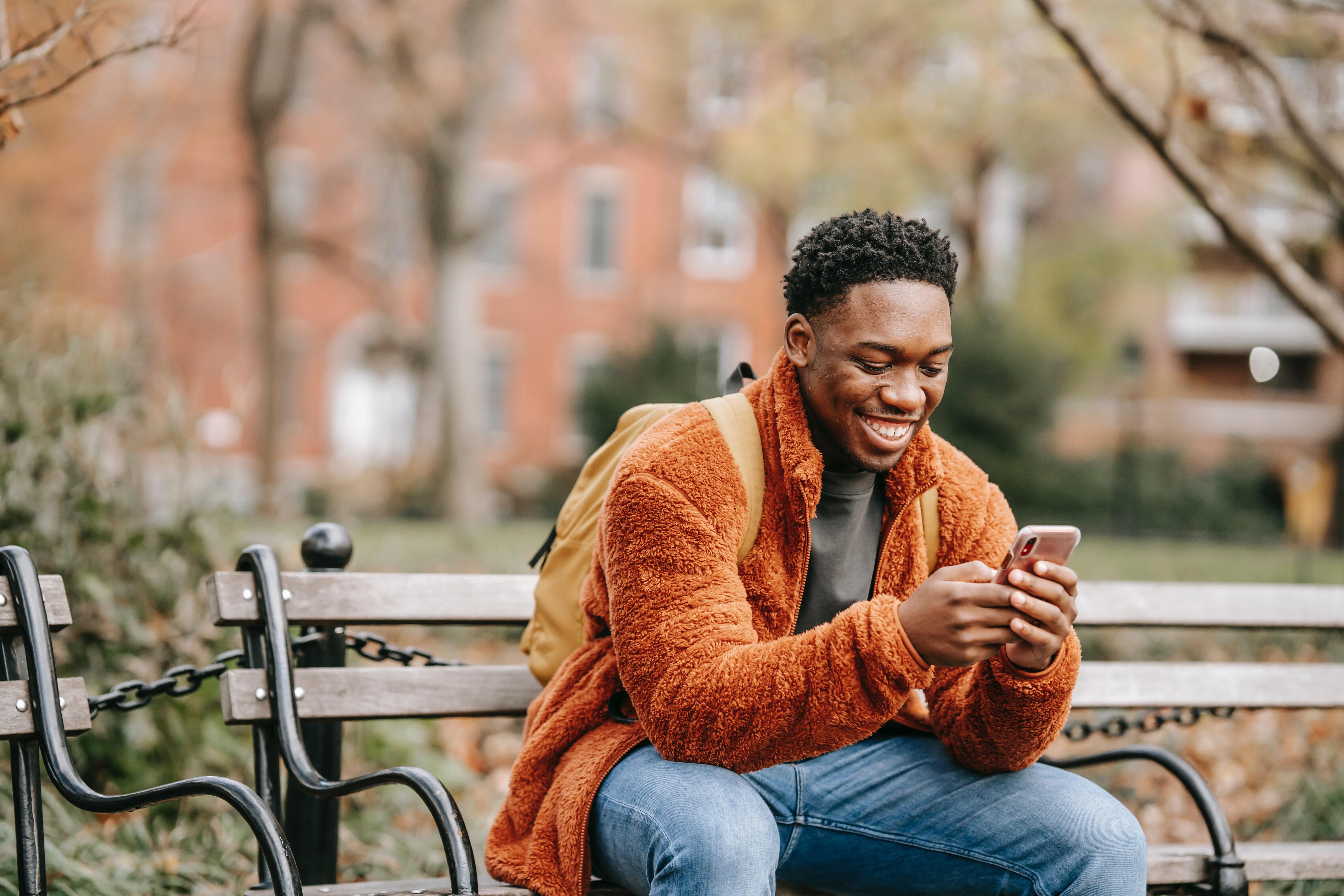 man on bench with phone