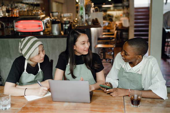 Three people talking in a coffee shop