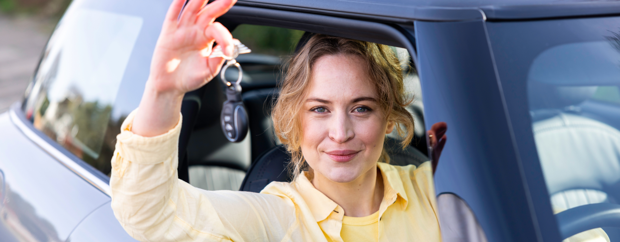 Woman with keys in a vehicle A woman sitting in a car holding the keys to the vehicle