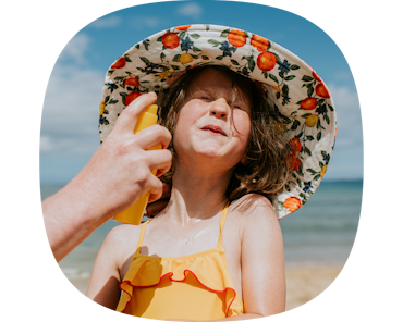 kid putting on sunscreen