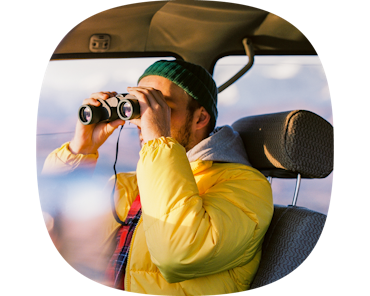 man looking through binoculars