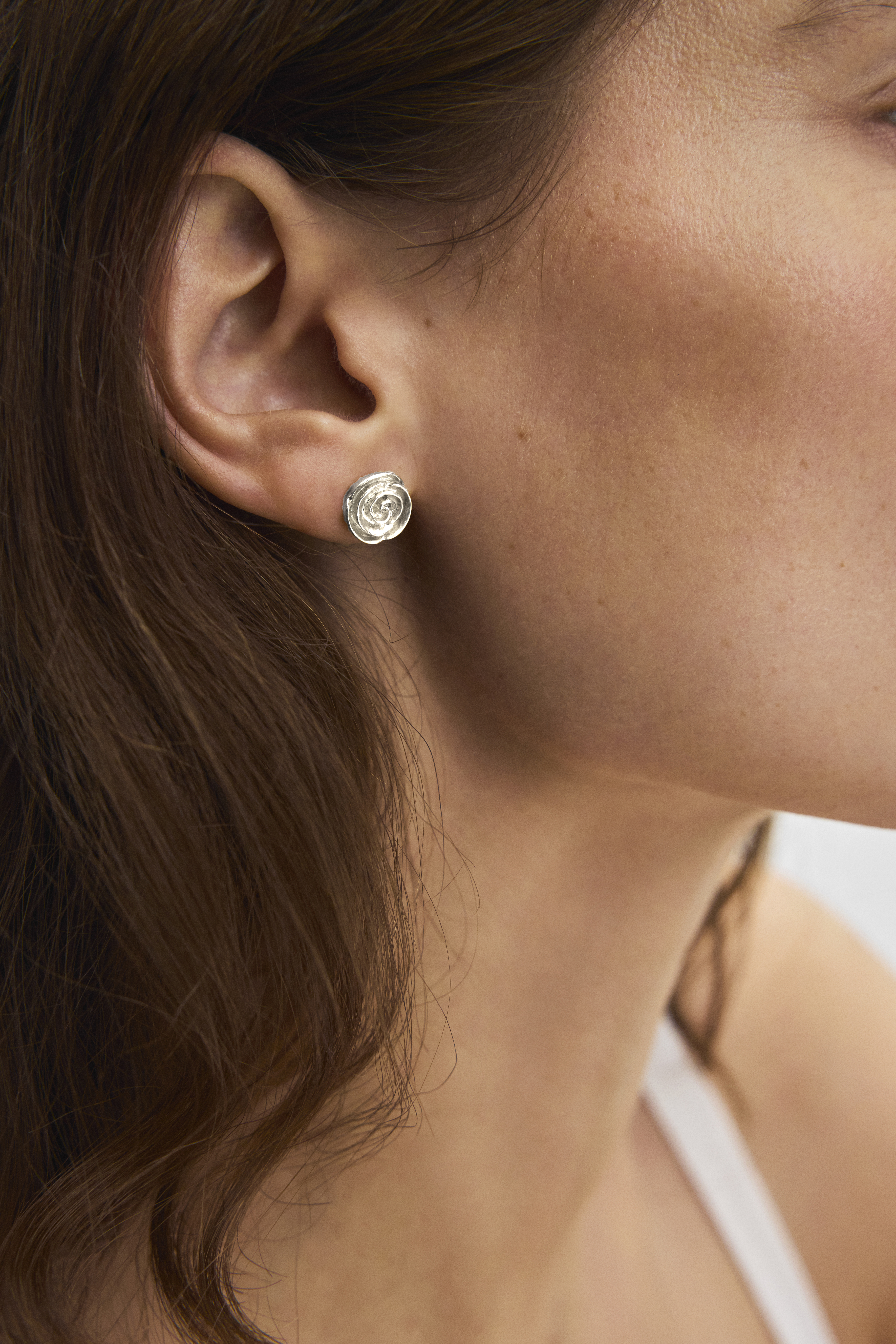 Woman with small silver rose earstick