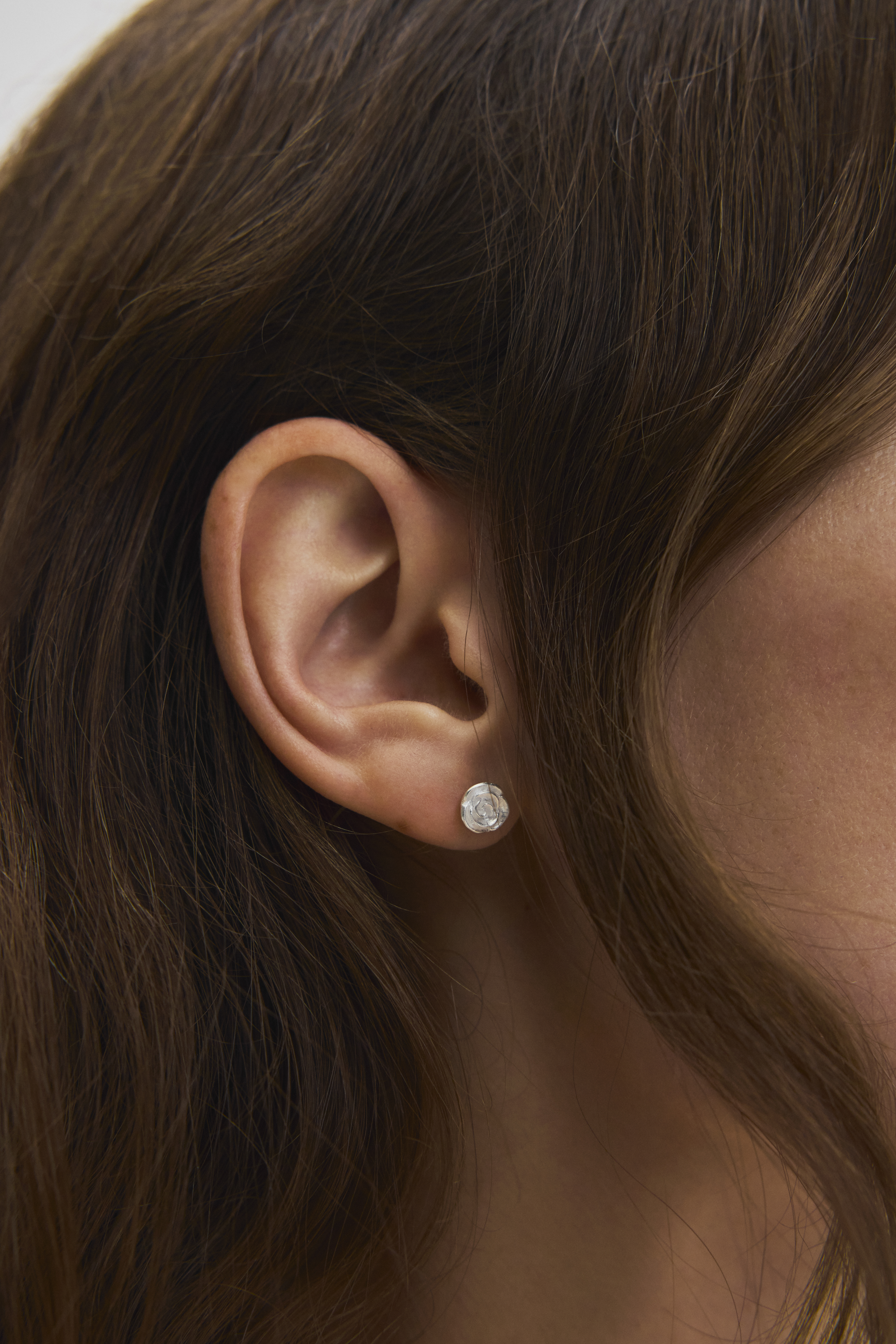 Woman with really small silver rose earstick