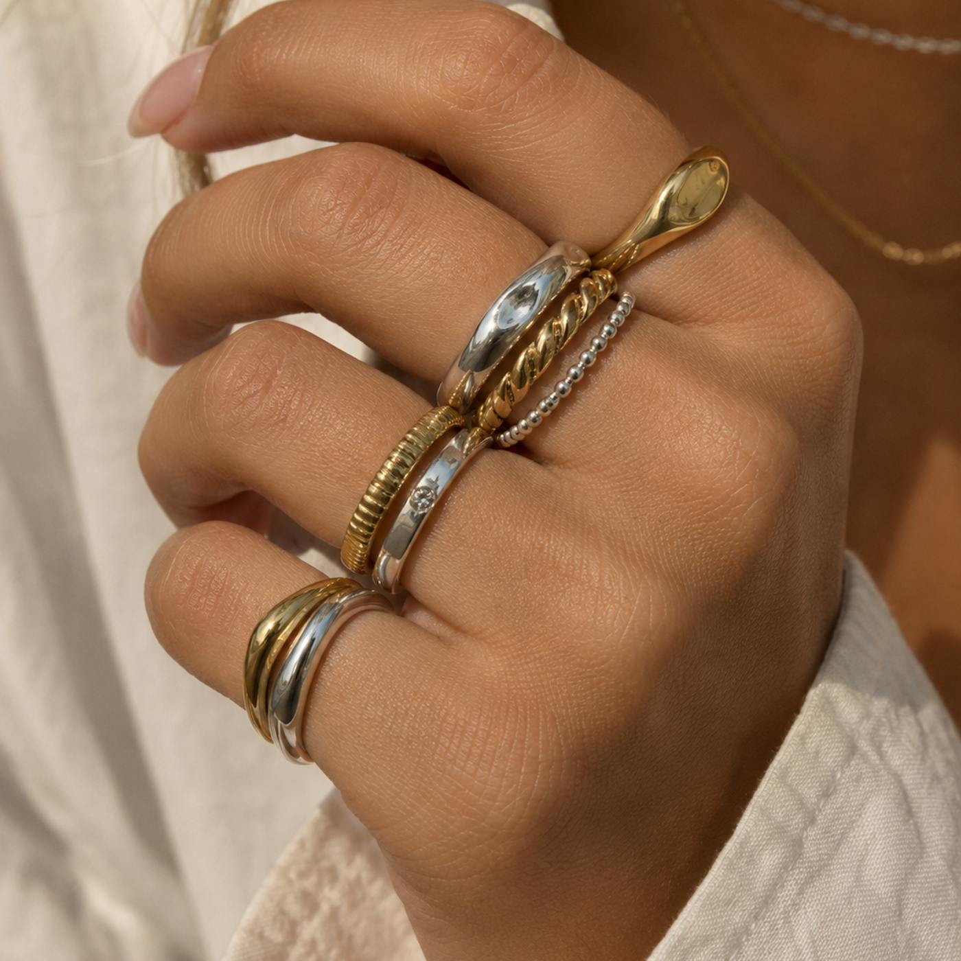 Can you mix gold and silver jewellery? Hand wearing stacked gold and silver rings