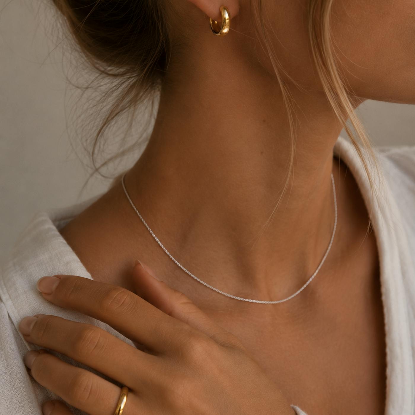 Can you mix gold and silver jewellery? Gold hoop earring worn with a fine silver necklace and a gold ring