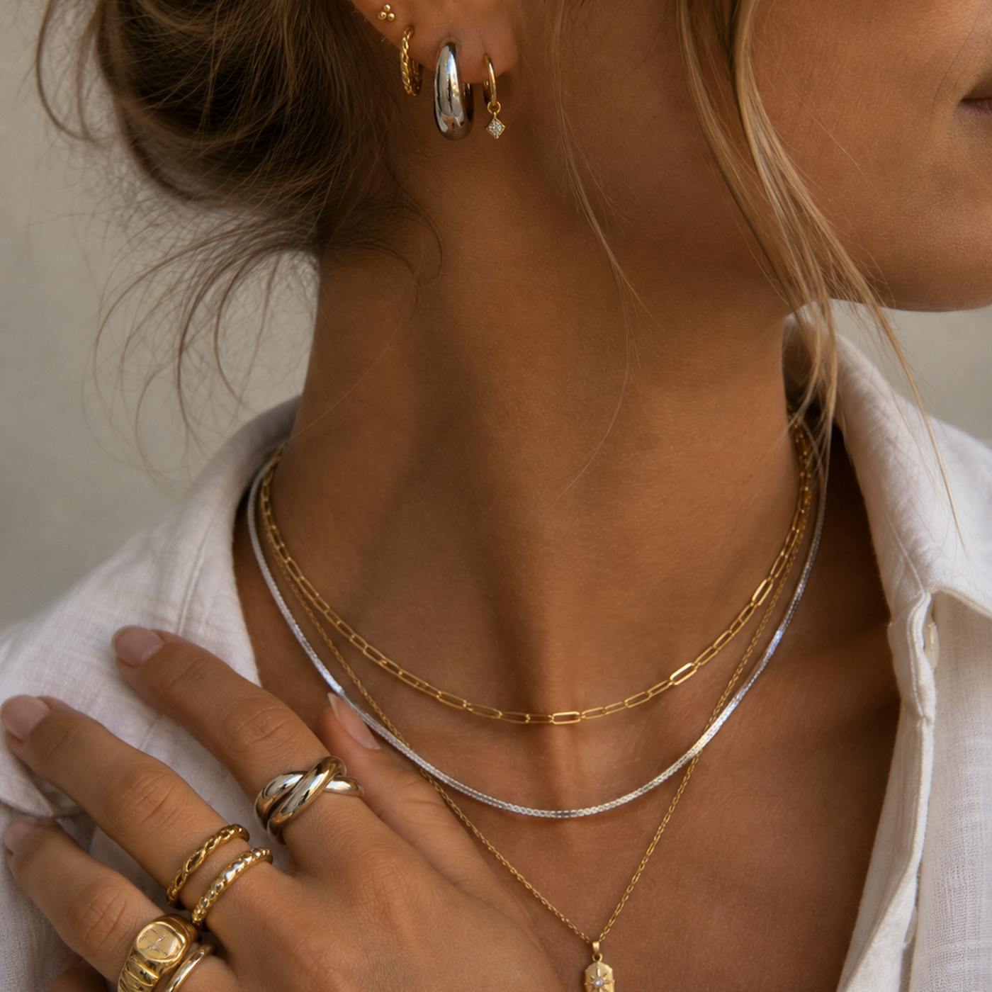 Can you mix gold and silver jewellery? Mixed metal look with silver and gold necklaces, silver hoops and stacked rings