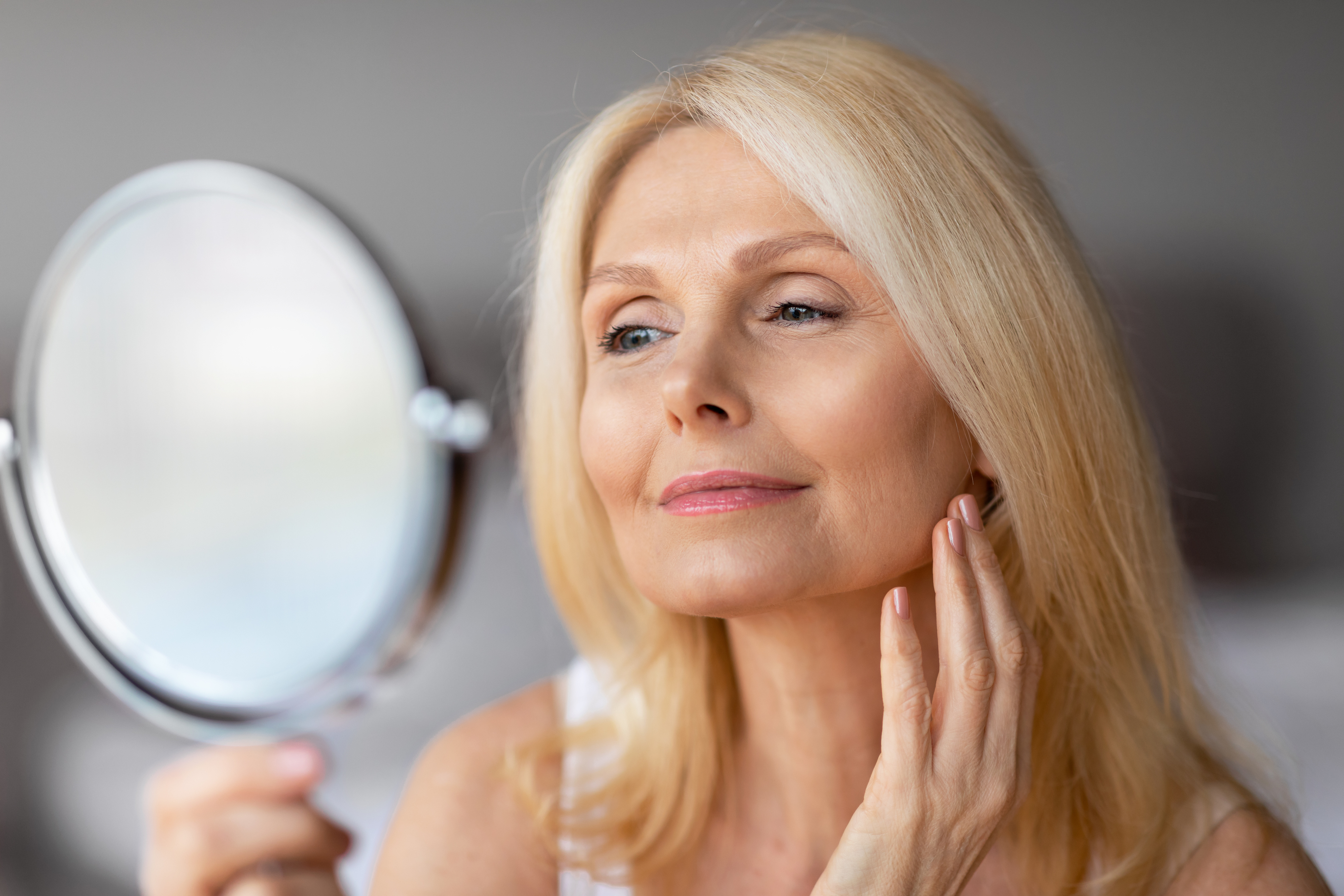 woman admiring her face in the mirror