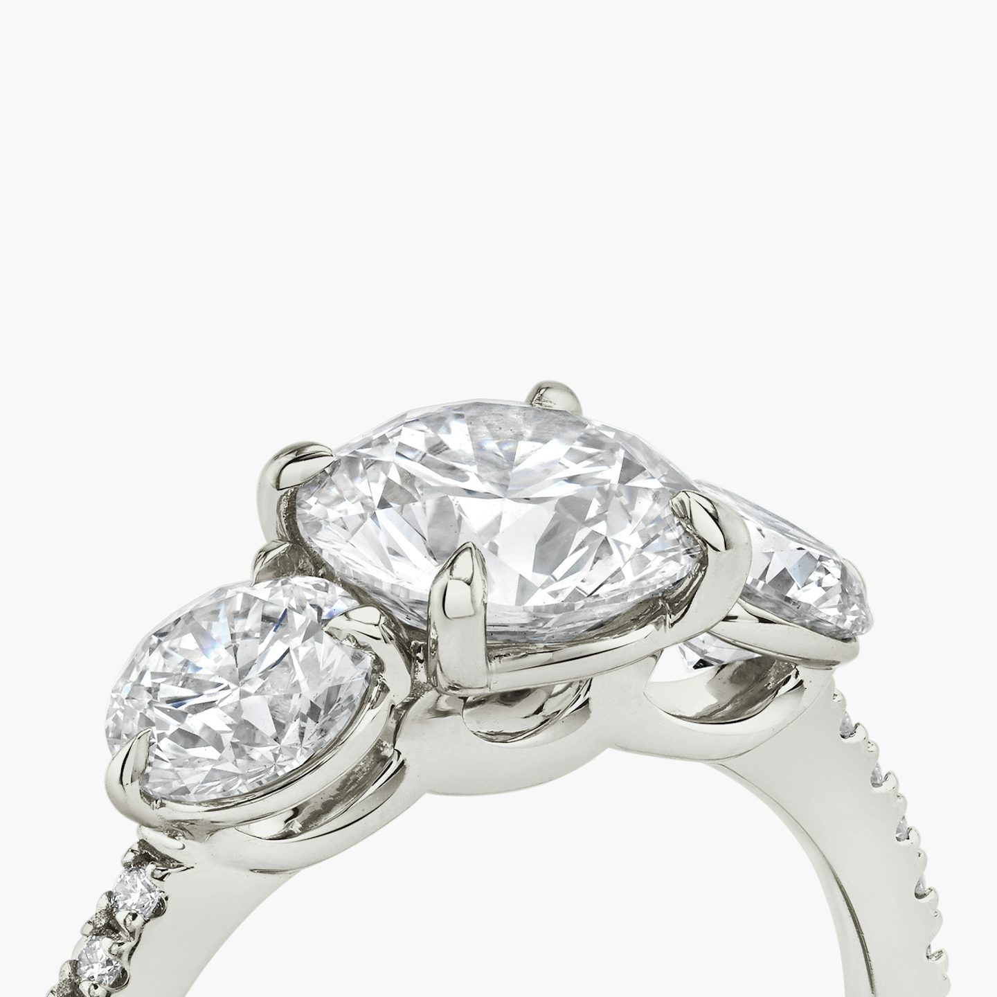 The Three Stone | Round Brilliant | 18k | 18k White Gold | Band: Pavé | Carat weight: See full inventory | Side stone carat: 1/2 | Side stone shape: Round Brilliant | Diamond orientation: vertical