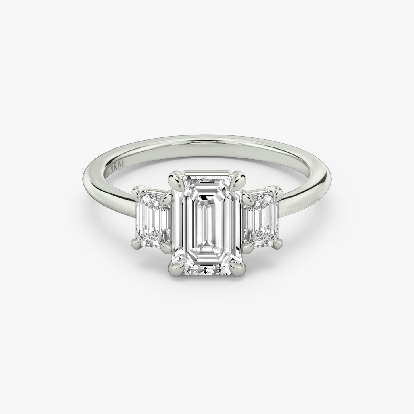 The Three Stone | emerald | 18k | white-gold | bandAccent: plain | sideStoneCarat: 0.25ct | sideStoneShape: emerald | diamondOrientation: vertical | caratWeight: other