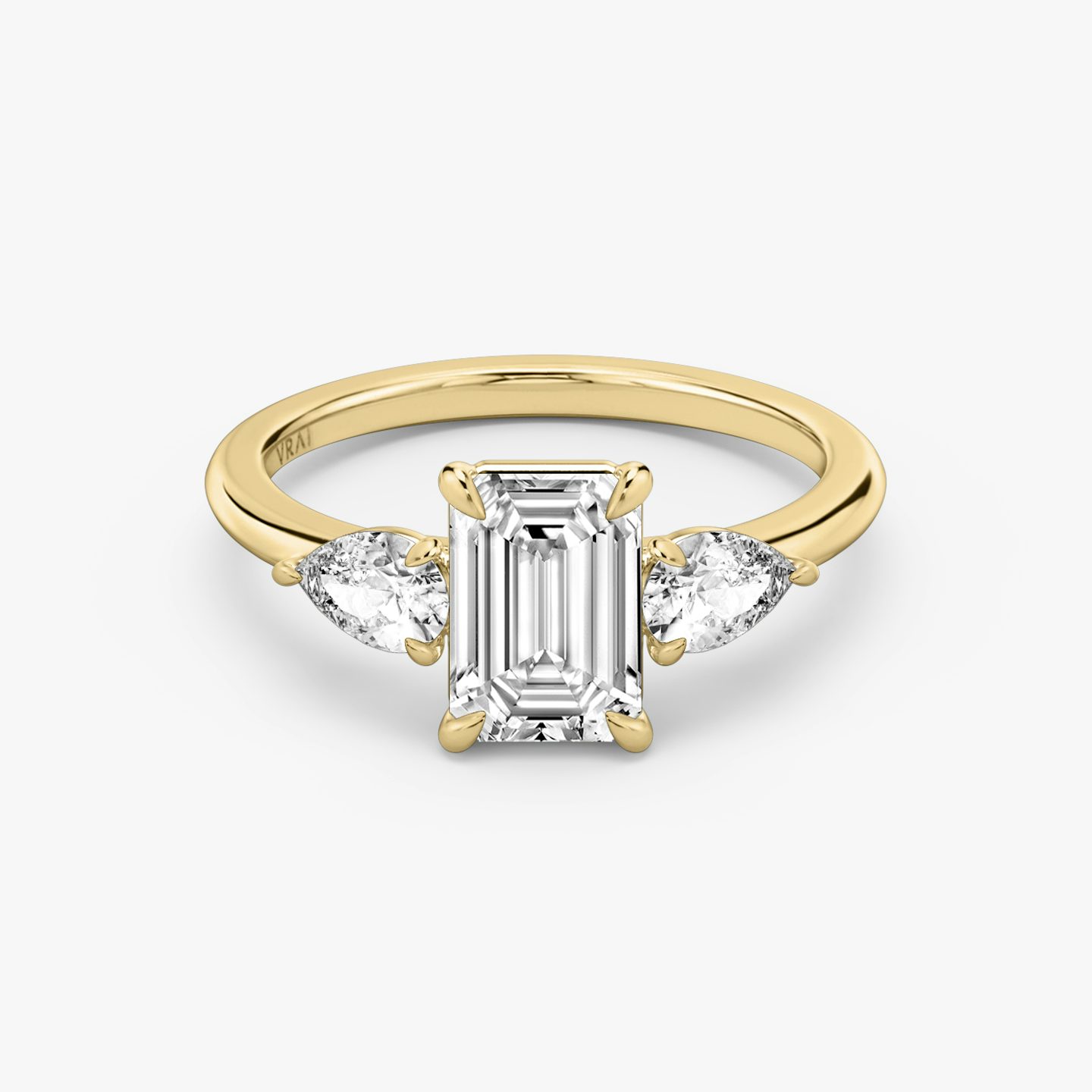 The Three Stone | emerald | 18k | yellow-gold | bandAccent: plain | sideStoneCarat: 0.25ct | sideStoneShape: pear | diamondOrientation: vertical | caratWeight: other