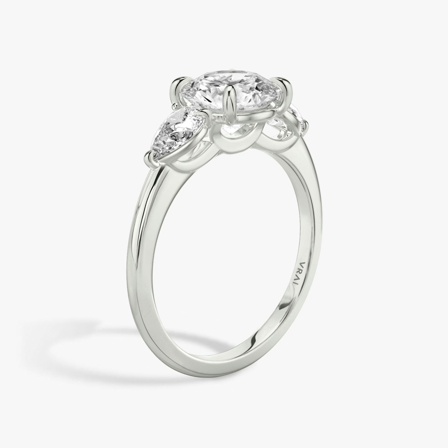 The Three Stone | Round Brilliant | 18k | 18k White Gold | Band: Plain | Carat weight: See full inventory | Side stone carat: 1/4 | Side stone shape: Pear | Diamond orientation: vertical