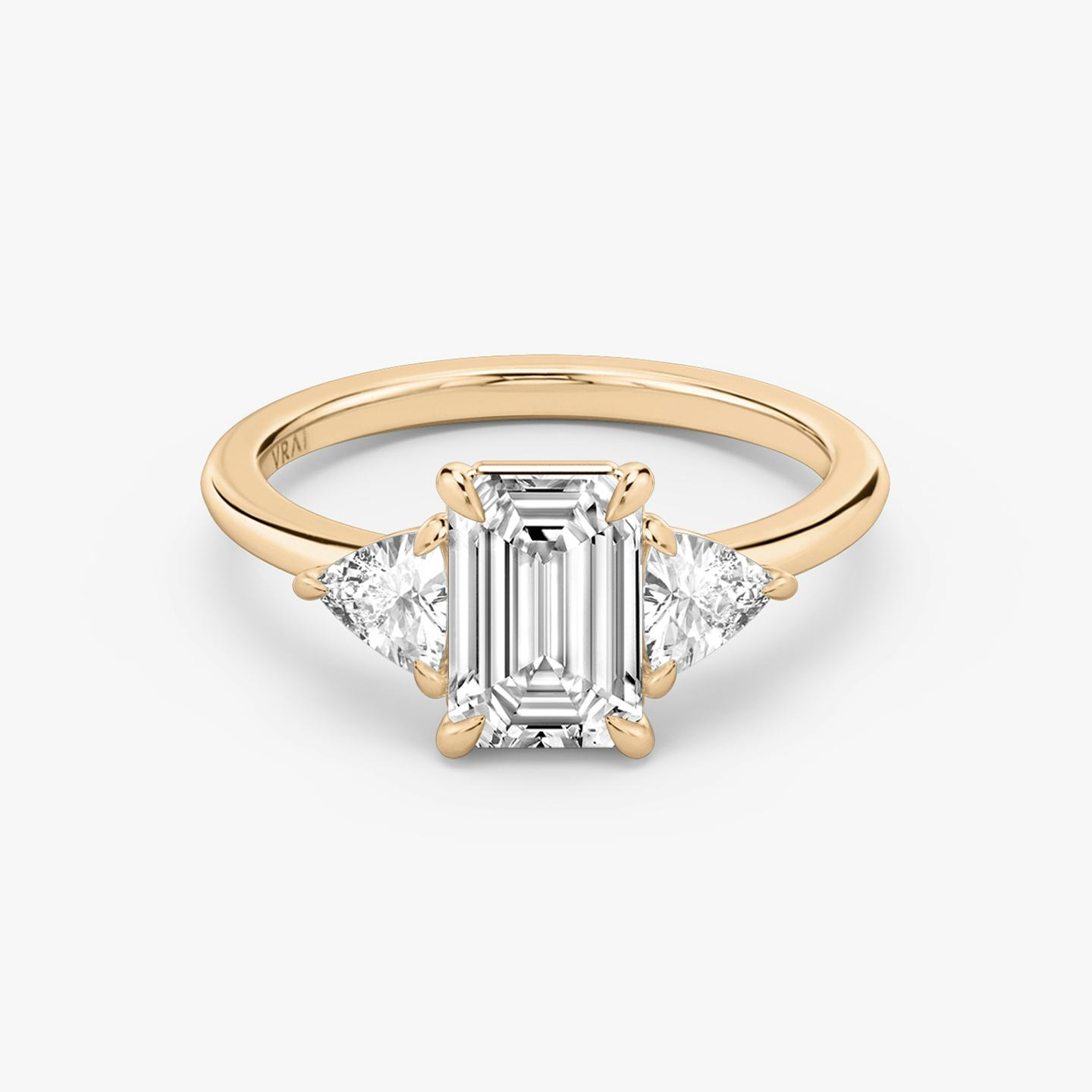 The Three Stone | Emerald | 14k | 14k Rose Gold | Band: Plain | Side stone carat: 1/4 | Side stone shape: Trillion | Diamond orientation: vertical | Carat weight: See full inventory