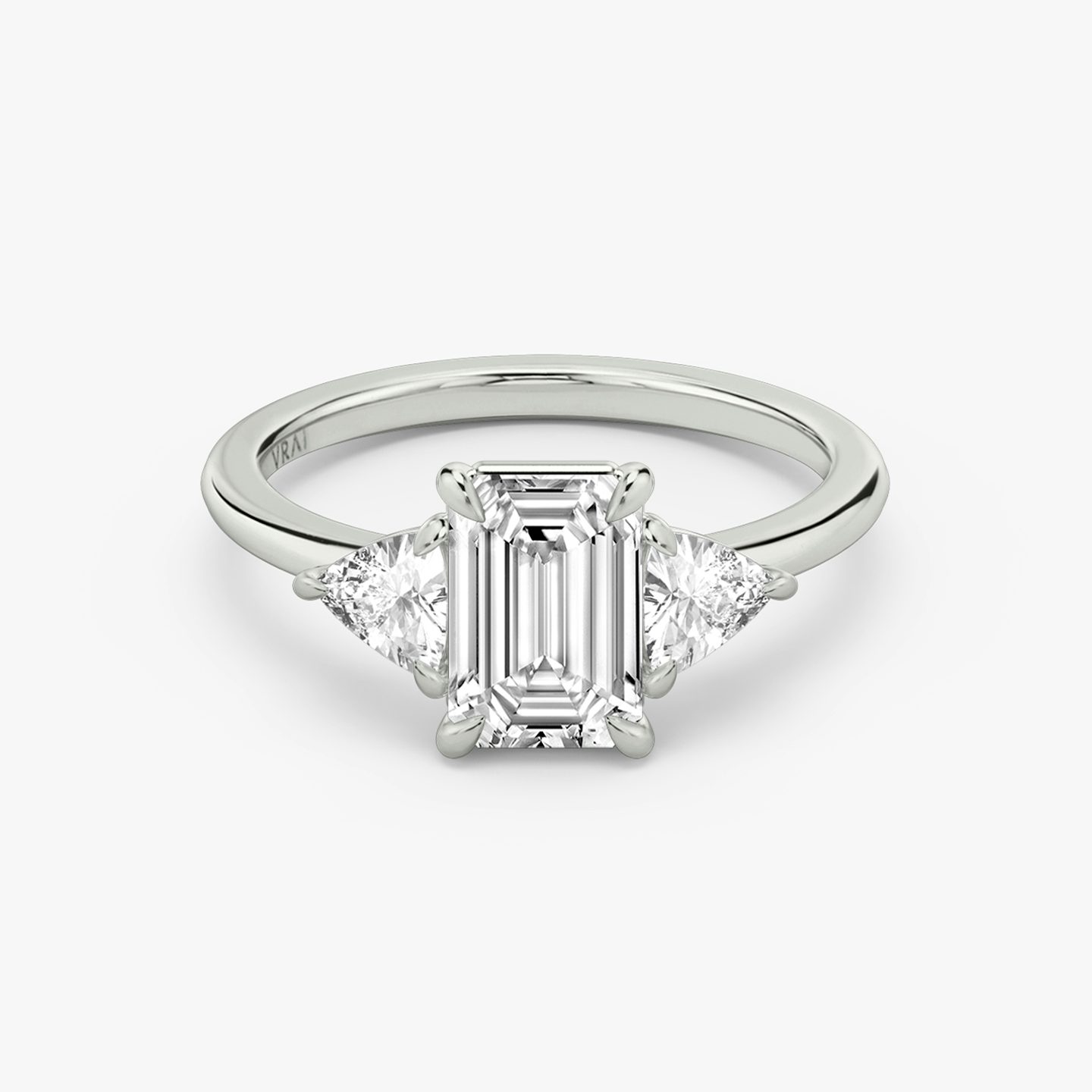 The Three Stone | emerald | 18k | white-gold | bandAccent: plain | sideStoneCarat: 0.25ct | sideStoneShape: trillion | diamondOrientation: vertical | caratWeight: other