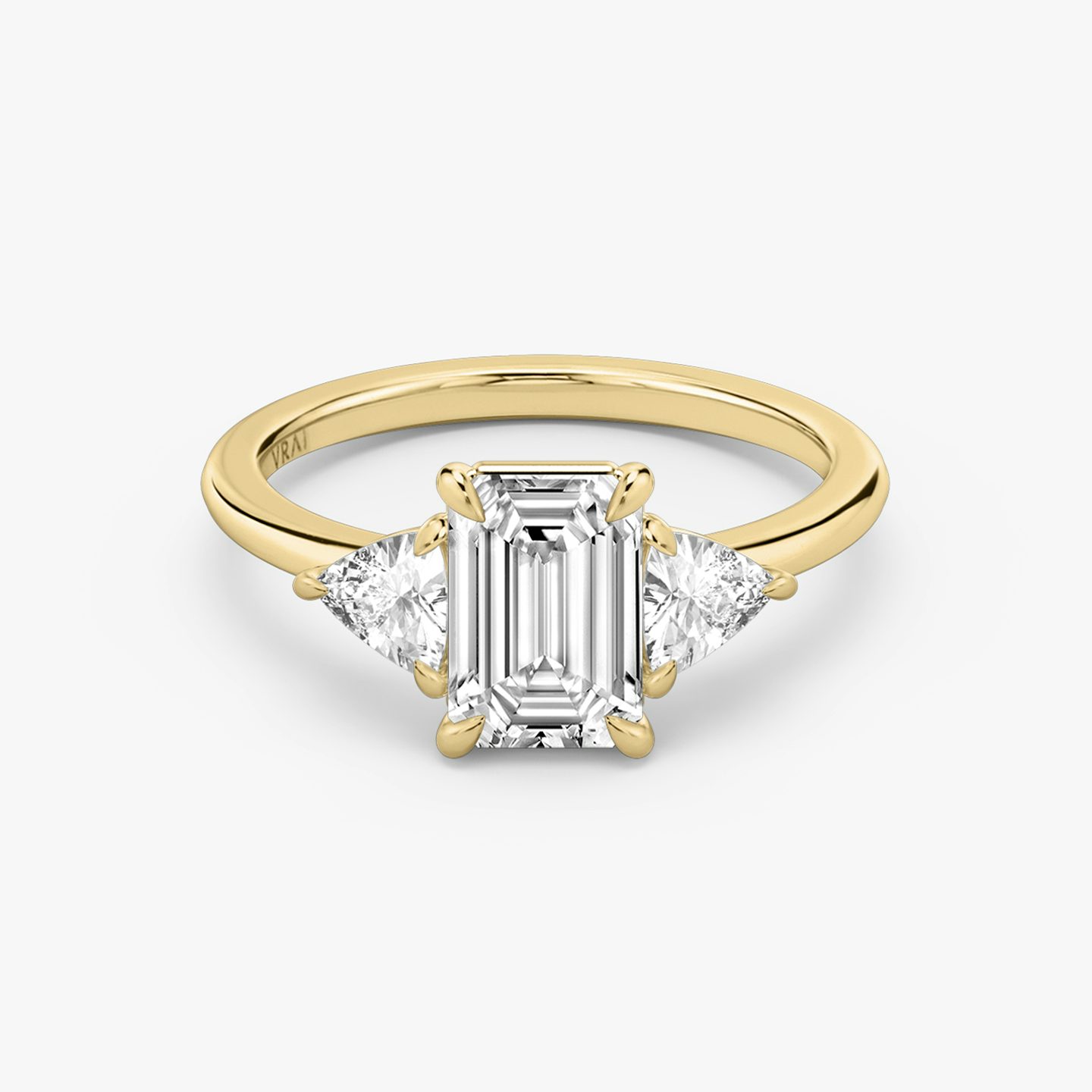 The Three Stone | emerald | 18k | yellow-gold | bandAccent: plain | sideStoneCarat: 0.25ct | sideStoneShape: trillion | diamondOrientation: vertical | caratWeight: other