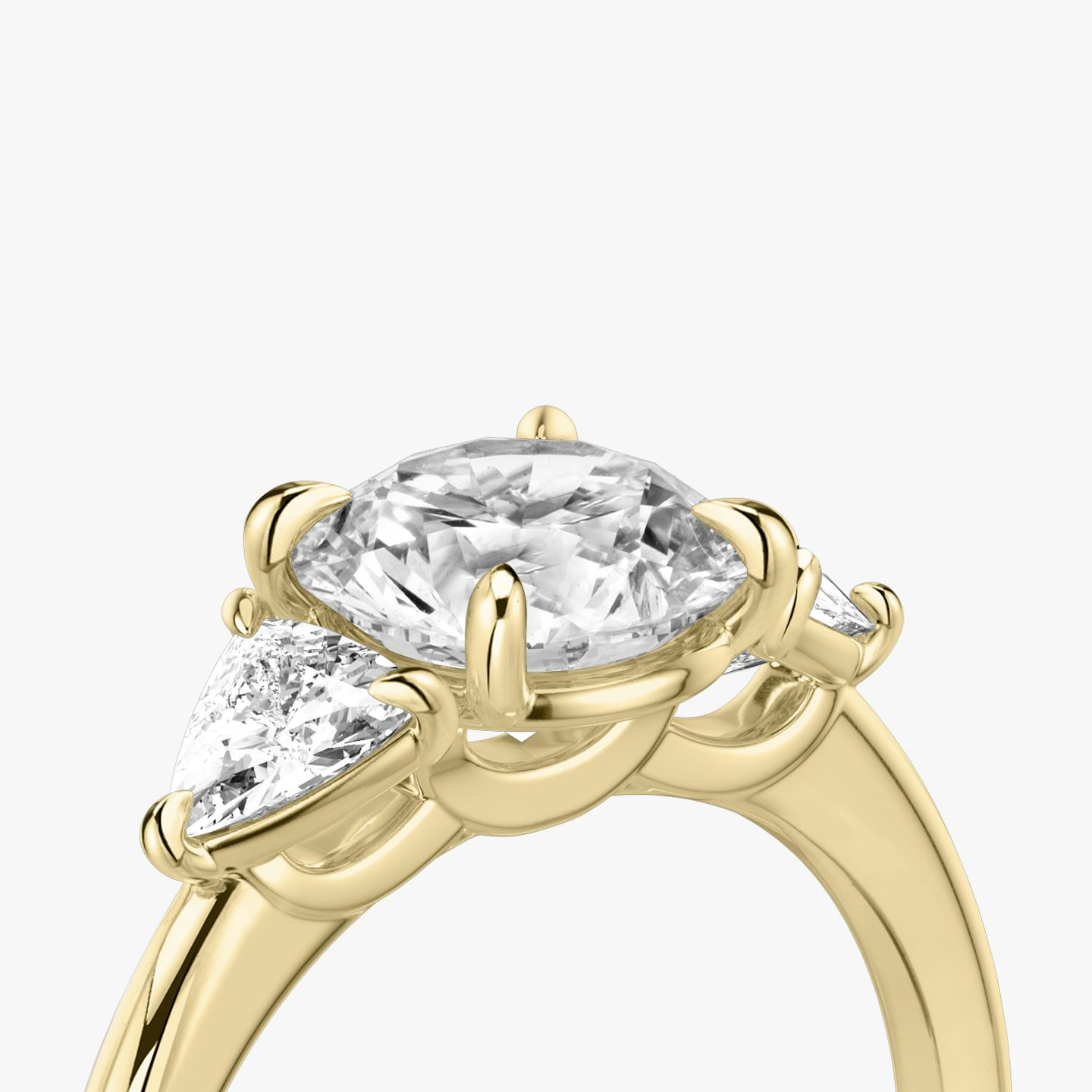 The Three Stone | Round Brilliant | 18k | 18k Yellow Gold | Band: Plain | Carat weight: See full inventory | Side stone carat: 1/4 | Side stone shape: Trillion | Diamond orientation: vertical