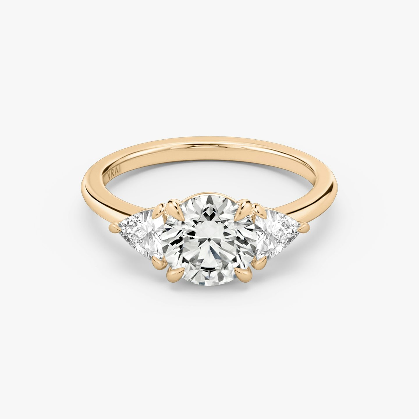 The Three Stone | Round Brilliant | 14k | 14k Rose Gold | Band: Plain | Carat weight: See full inventory | Side stone carat: 1/4 | Side stone shape: Trillion | Diamond orientation: vertical
