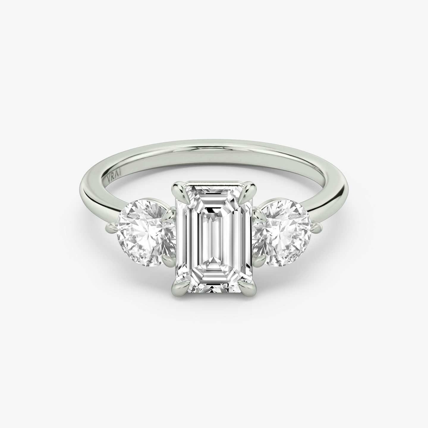 Three Stone | emerald | 18k | white-gold | bandAccent: plain | sideStoneCarat: 0.50ct | sideStoneShape: round-brilliant | diamondOrientation: vertical | caratWeight: other