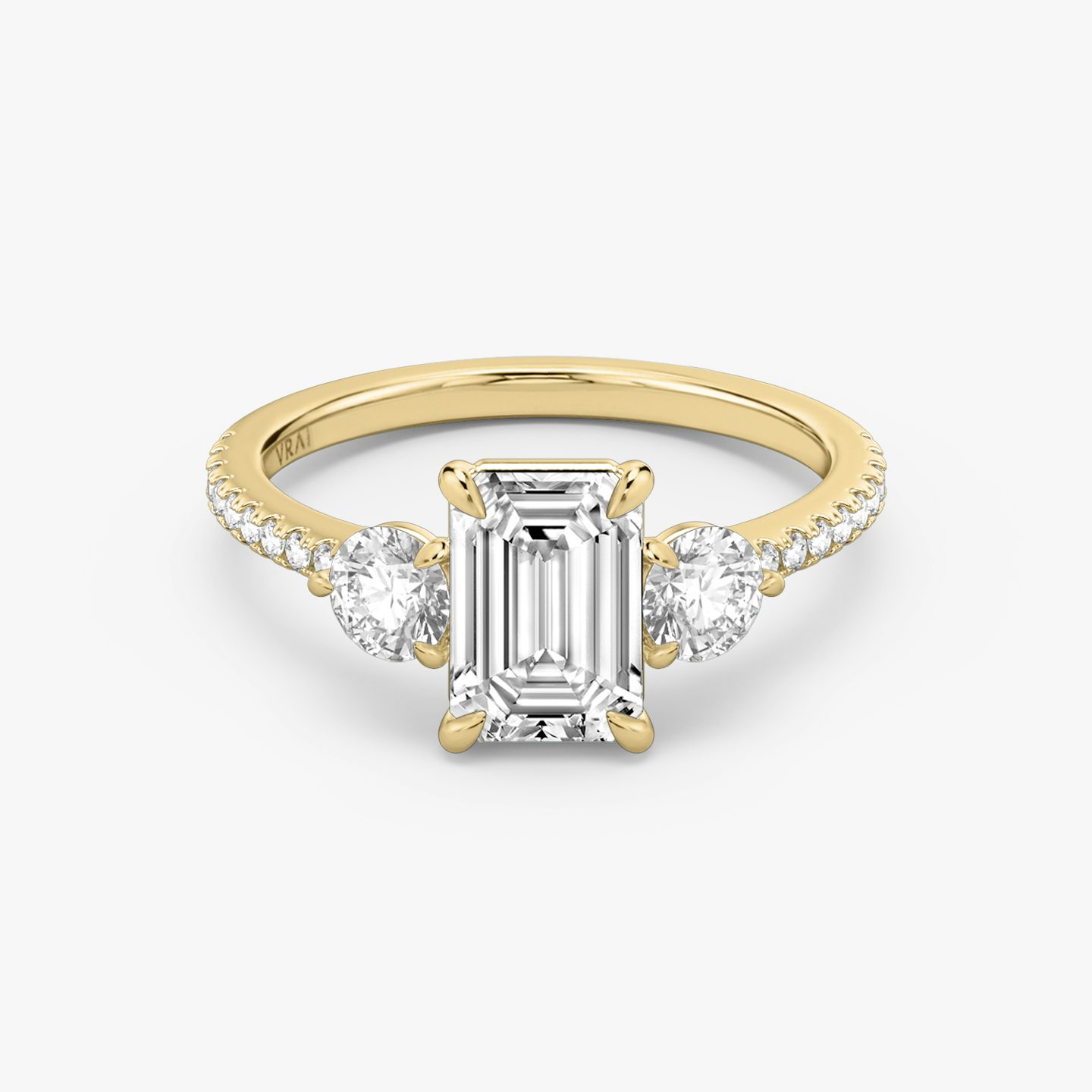 The Three Stone | emerald | 18k | yellow-gold | bandAccent: pave | sideStoneCarat: 0.25ct | sideStoneShape: round-brilliant | diamondOrientation: vertical | caratWeight: other