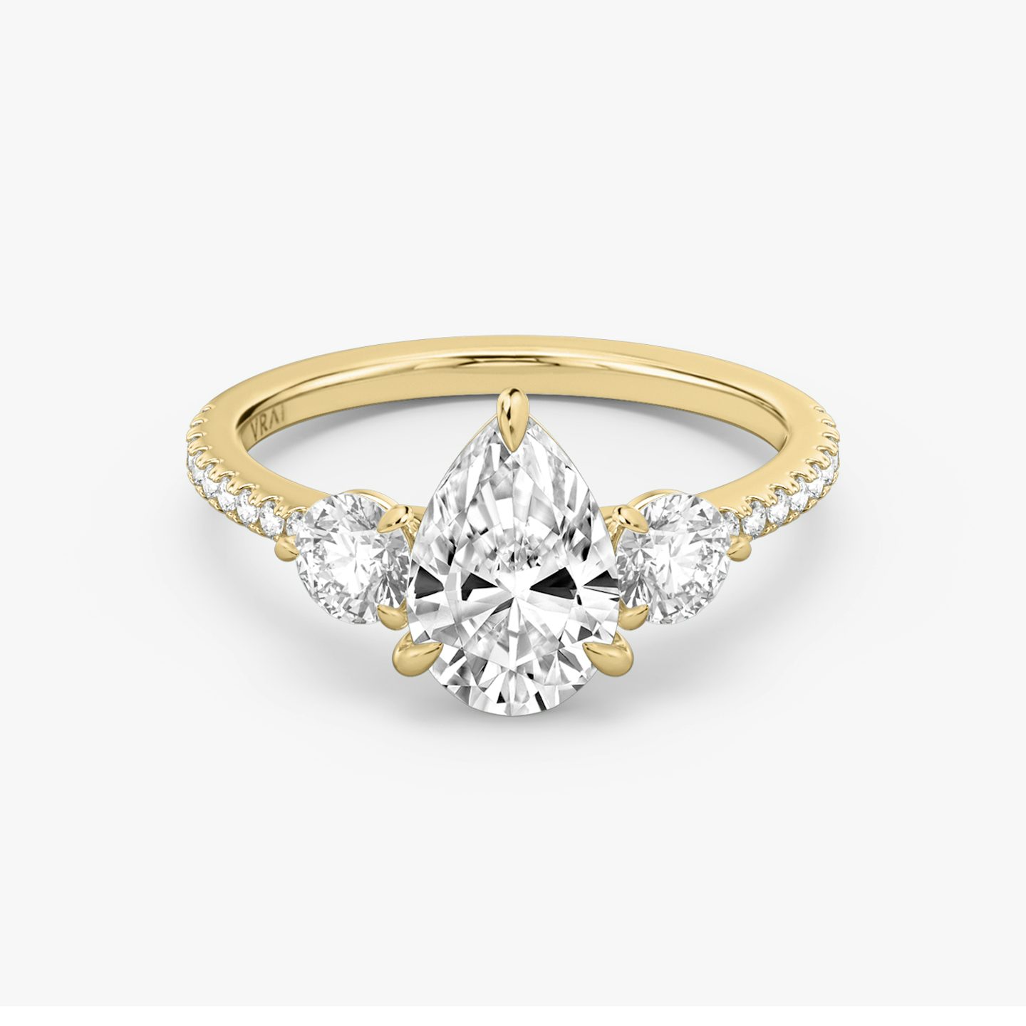 The Three Stone | Pear | 18k | 18k Yellow Gold | Band: Pavé | Side stone carat: 1/4 | Side stone shape: Round Brilliant | Diamond orientation: vertical | Carat weight: See full inventory