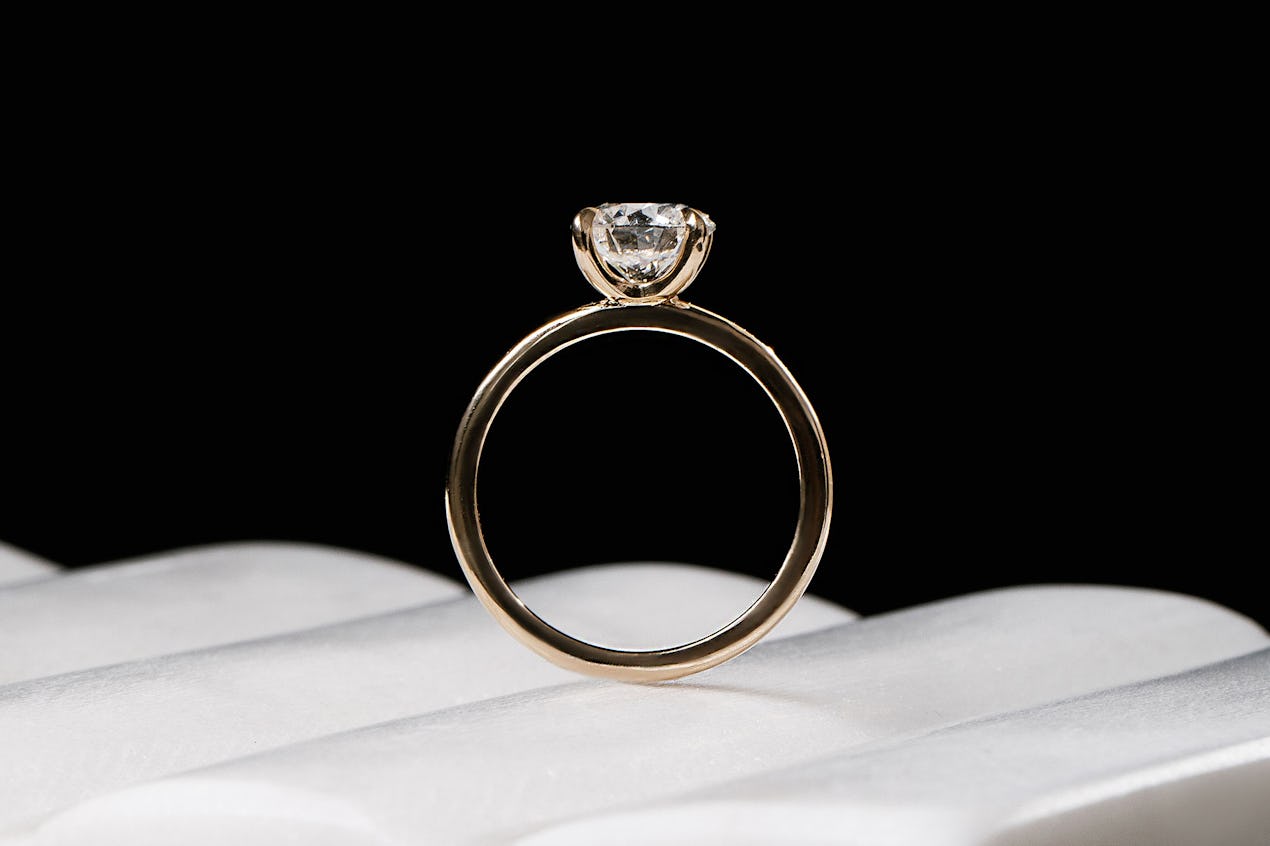 The classic round brilliant engagement ring with yellow gold band 