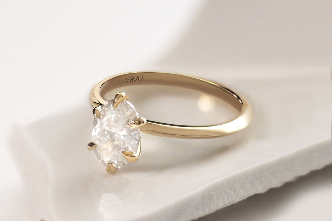 The oval knife edge engagement ring with yellow gold band 