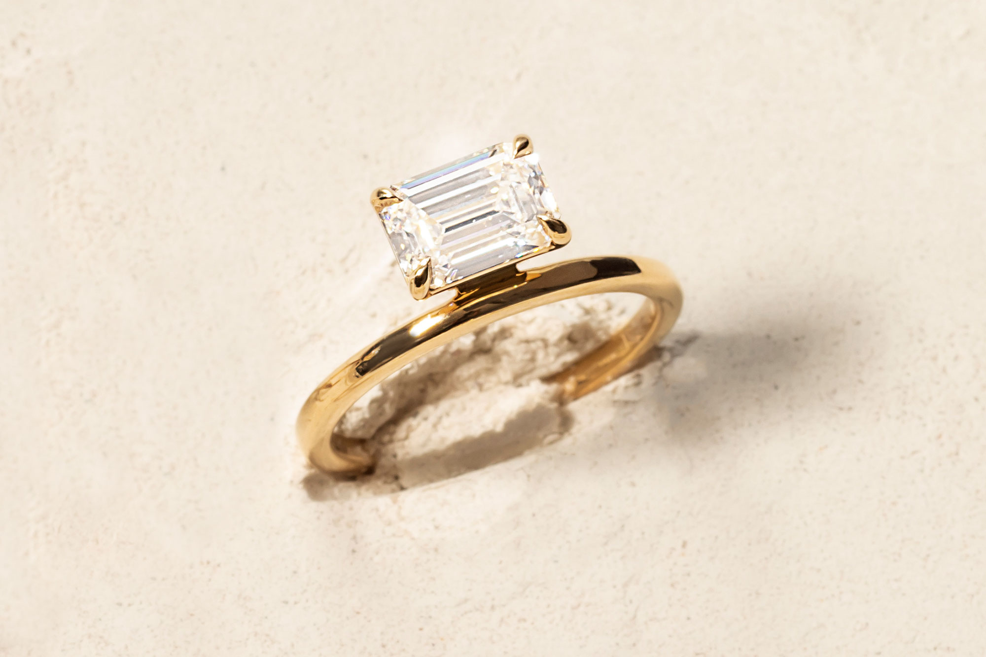 the emerald hover engagement ring with yellow gold band