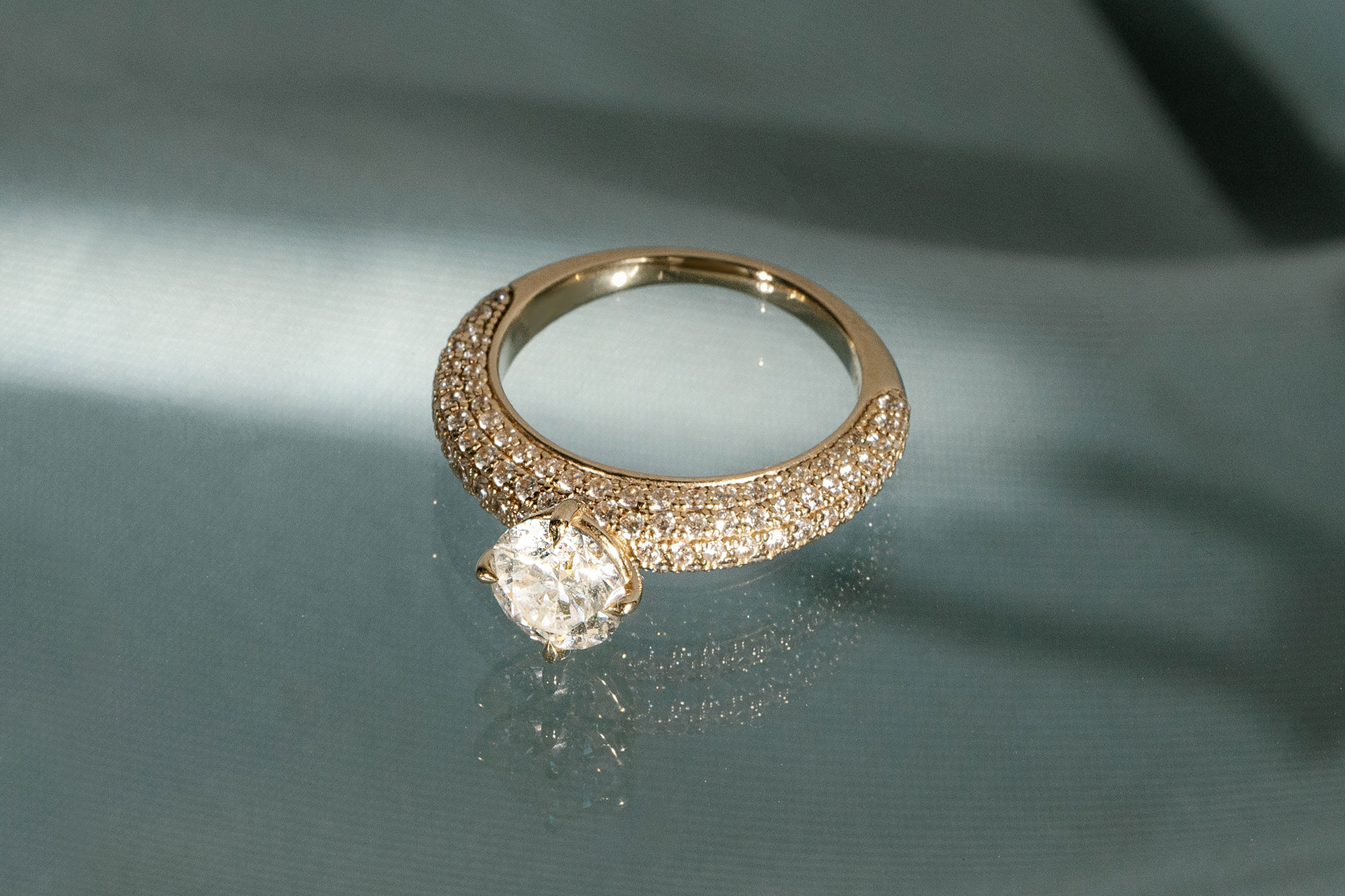 the round brilliant curator engagement ring with yellow gold pave band