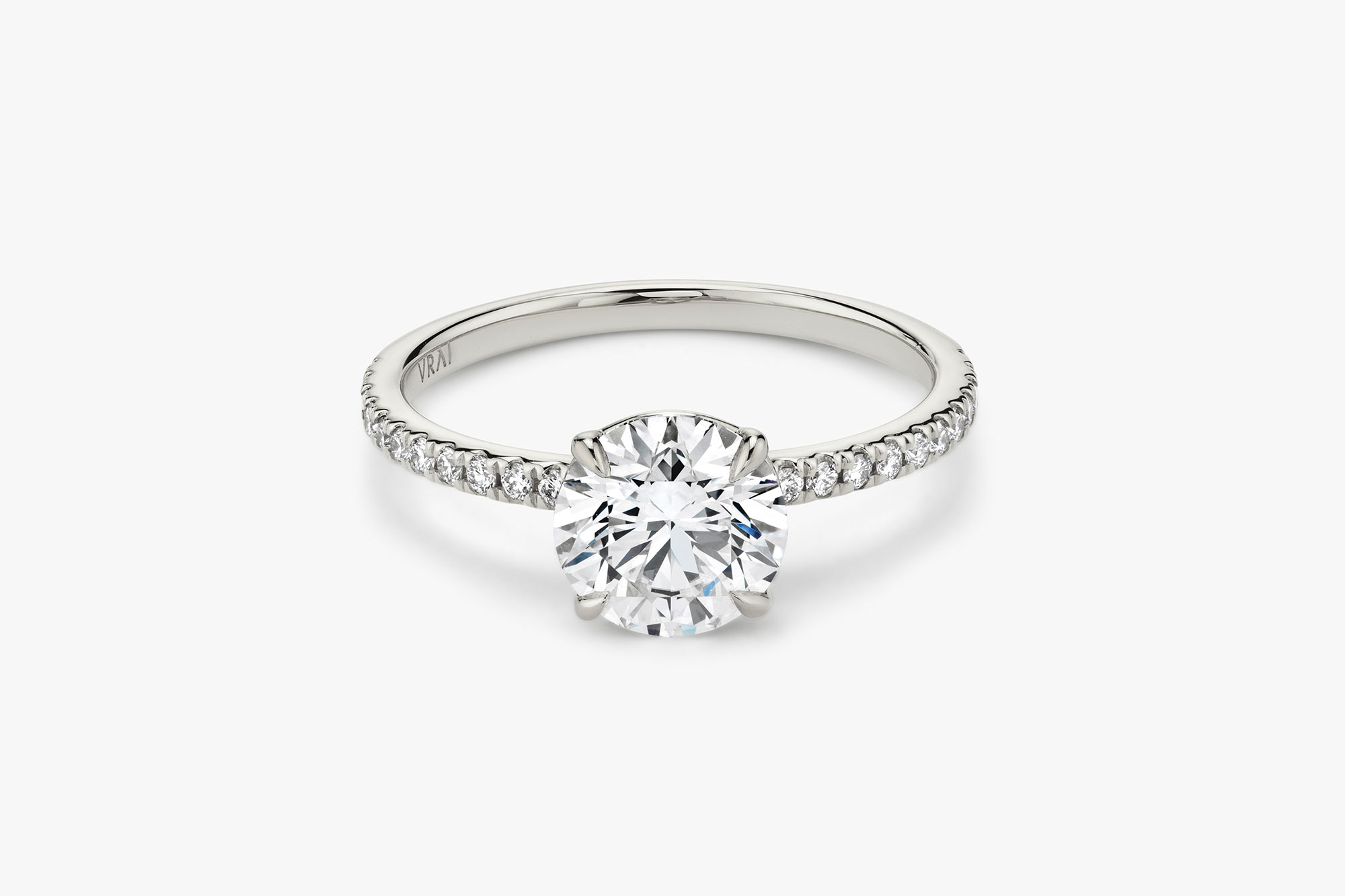 The Signature solitaire ring in 18k white gold with a round brilliant cut diamond and pavé band