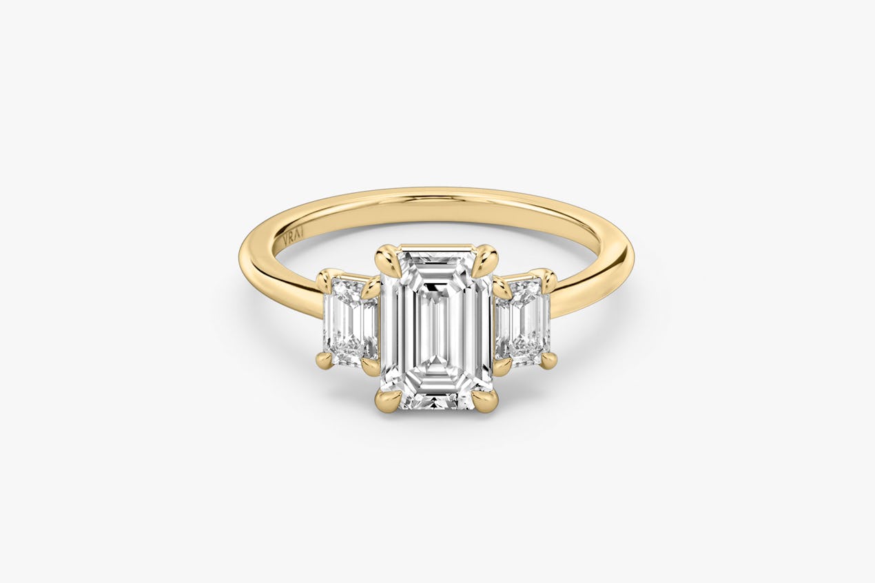 The Three Stone ring in 18k yellow gold with an emerald cut diamond