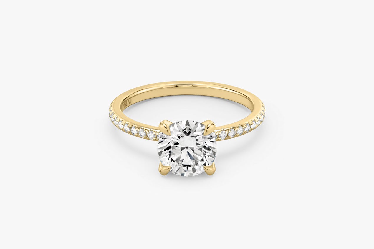 The Classic solitaire in 18k yellow gold with a round brilliant cut diamond and pavé band