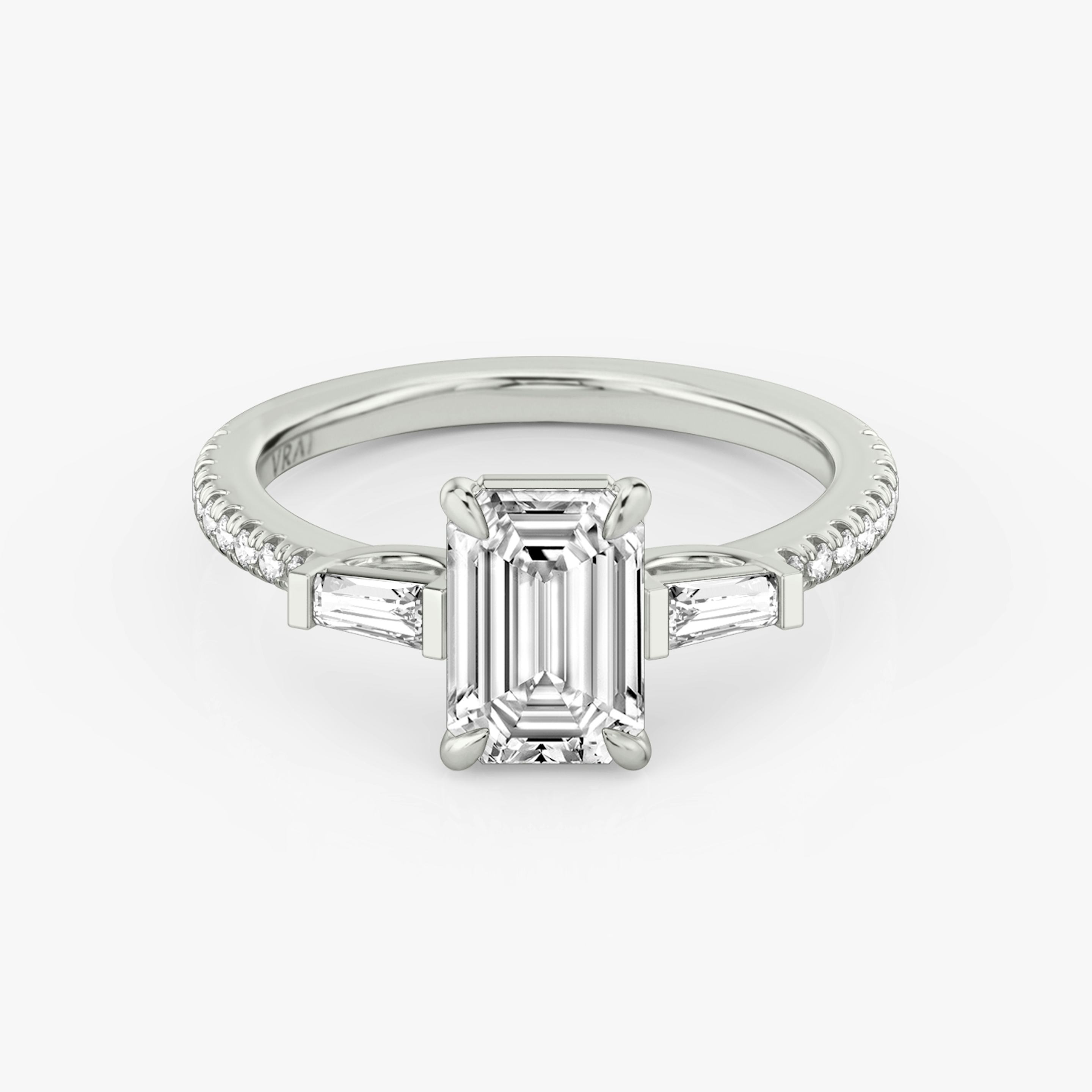 The Three Stone | Emerald | Platinum | Band: Pavé | Side stone carat: 1/10 | Side stone shape: Tapered Baguette | Diamond orientation: vertical | Carat weight: See full inventory
