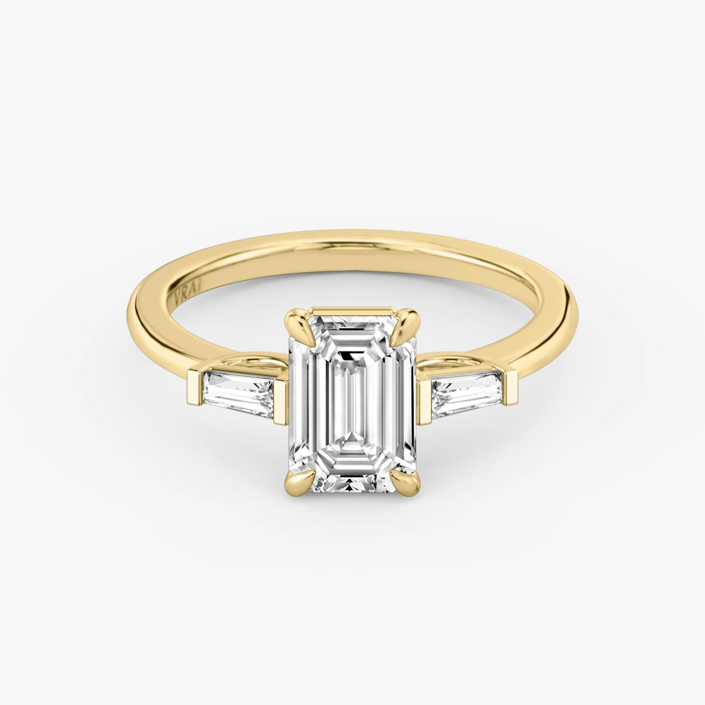 The Three Stone | Emerald | 18k | 18k Yellow Gold | Band: Plain | Side stone carat: 1/10 | Side stone shape: Tapered Baguette | Diamond orientation: vertical | Carat weight: See full inventory