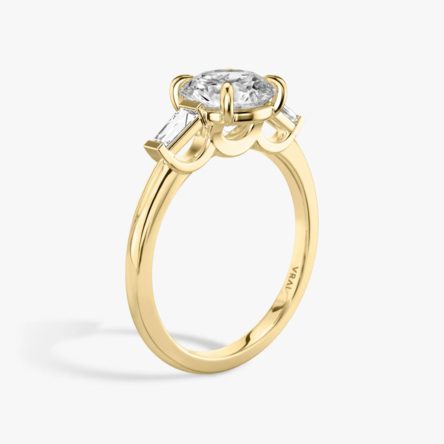 The Three Stone | Round Brilliant | 18k | 18k Yellow Gold | Band: Plain | Carat weight: See full inventory | Side stone carat: 1/10 | Side stone shape: Tapered Baguette | Diamond orientation: vertical