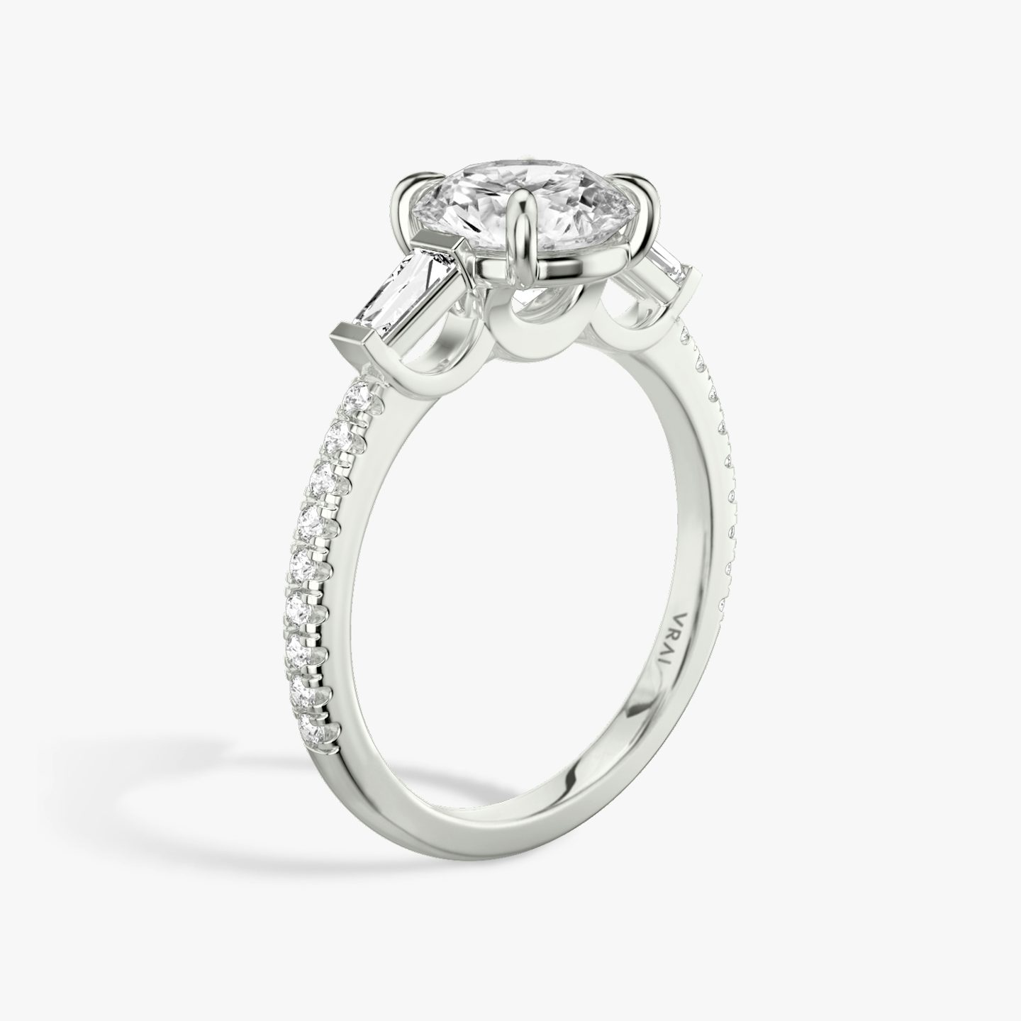 The Three Stone | Round Brilliant | 18k | 18k White Gold | Band: Pavé | Carat weight: 1 | Side stone carat: 1/10 | Side stone shape: Tapered Baguette | Diamond orientation: vertical