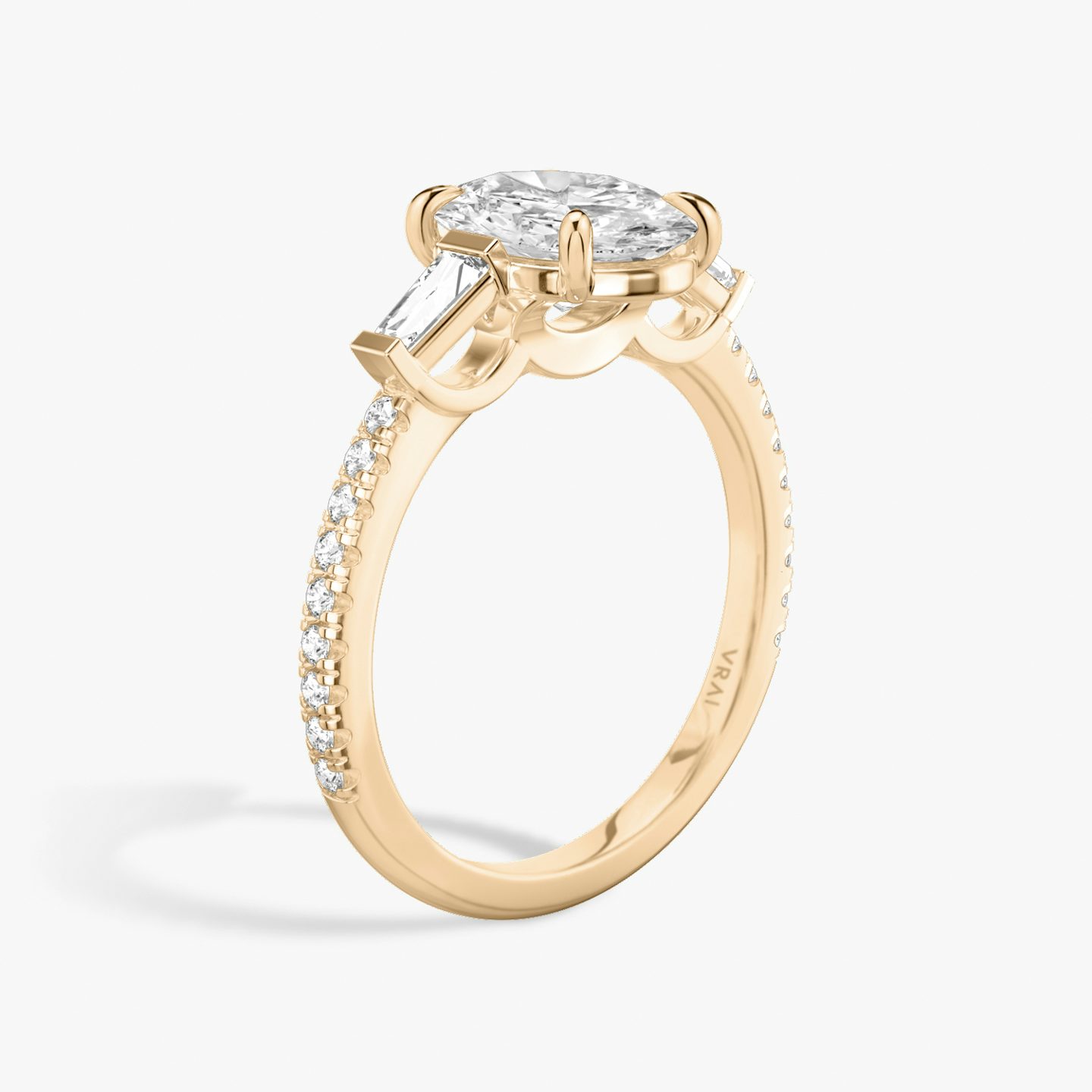 The Three Stone | Oval | 14k | 14k Rose Gold | Band: Pavé | Side stone carat: 1/10 | Side stone shape: Tapered Baguette | Diamond orientation: vertical | Carat weight: See full inventory