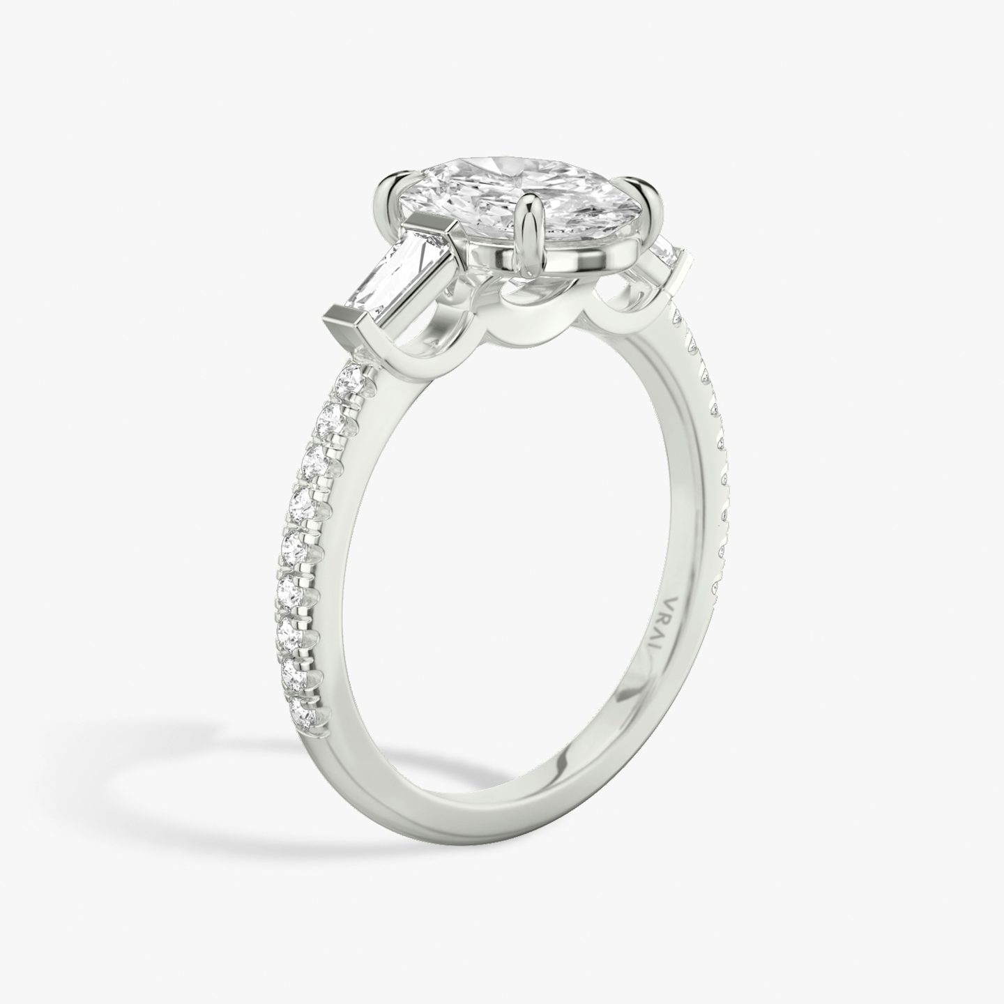 The Three Stone | Oval | 18k | 18k White Gold | Band: Pavé | Side stone carat: 1/10 | Side stone shape: Tapered Baguette | Diamond orientation: vertical | Carat weight: See full inventory