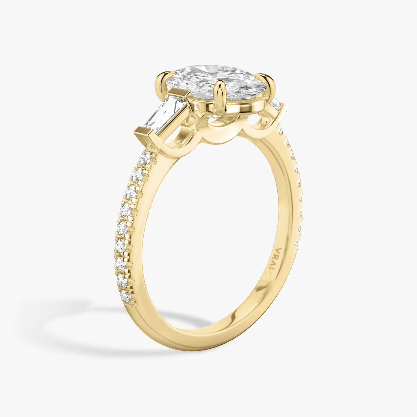 The Three Stone | Oval | 18k | 18k Yellow Gold | Band: Pavé | Side stone carat: 1/10 | Side stone shape: Tapered Baguette | Diamond orientation: vertical | Carat weight: See full inventory