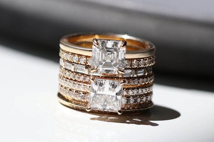 two princess cut engagement rings stacked on top of each other