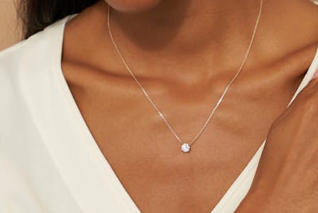 A model wearing a 1 carat Round Brilliant Solitaire Necklace