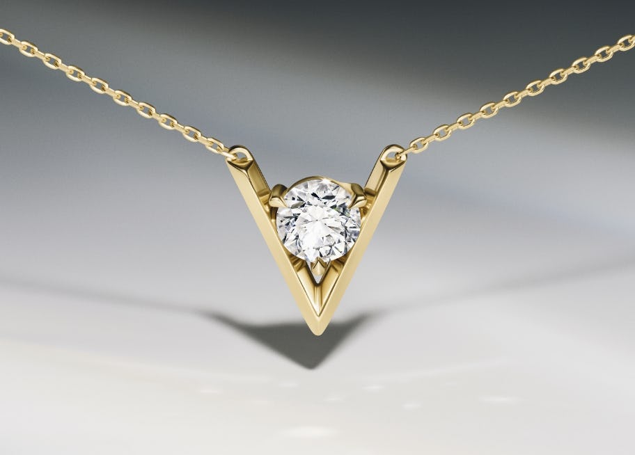 close up of necklace with a v shaped design in gold surrounding a lab grown diamond
