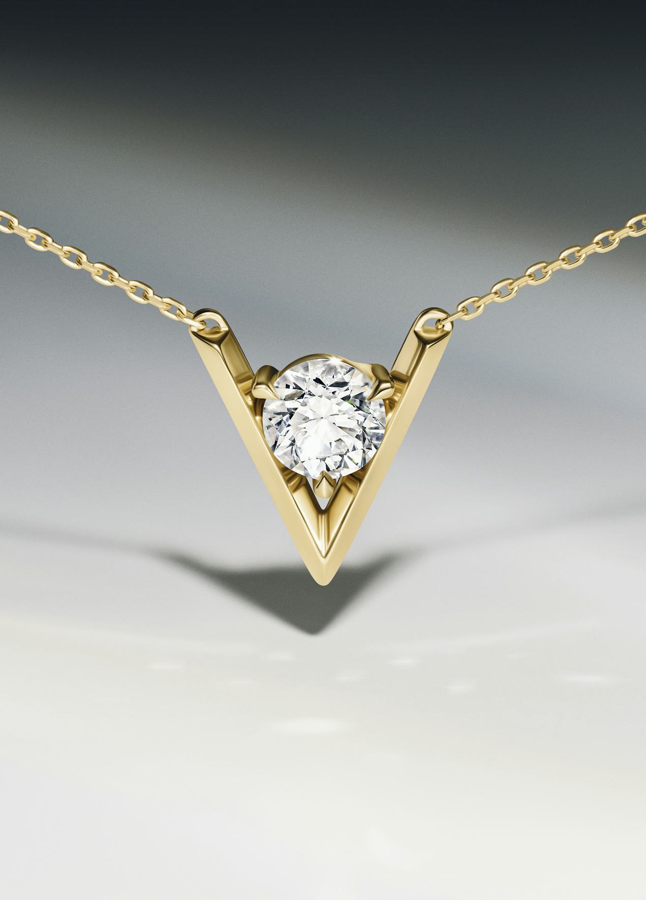 close up of necklace with a v shaped design in gold surrounding a lab grown diamond
