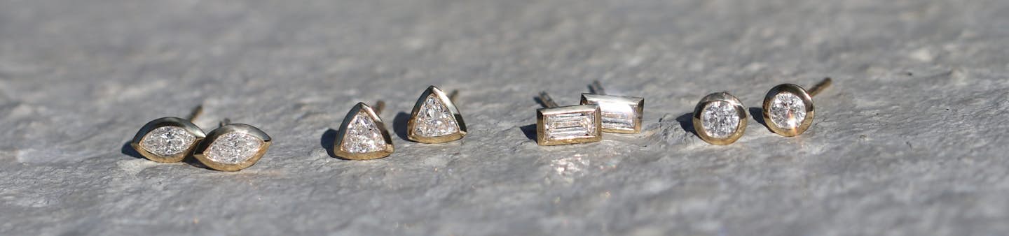 four different types of earrings with lab diamonds of different shapes