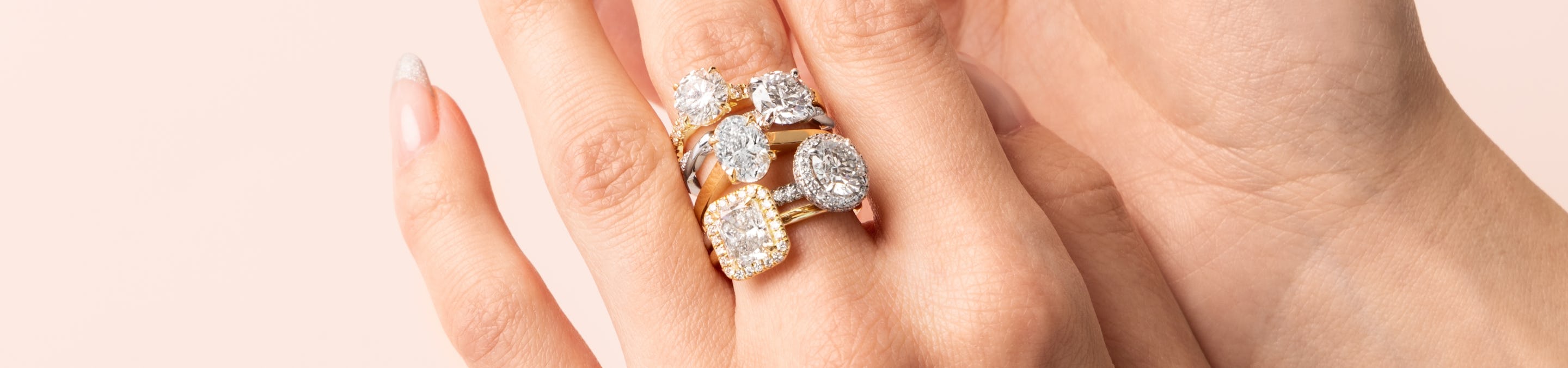 hand showcasing five engagement styles including solitaire, halo, pave and more