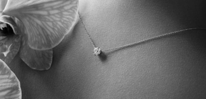 lab grown diamond necklace around the neck with flowers accenting the image
