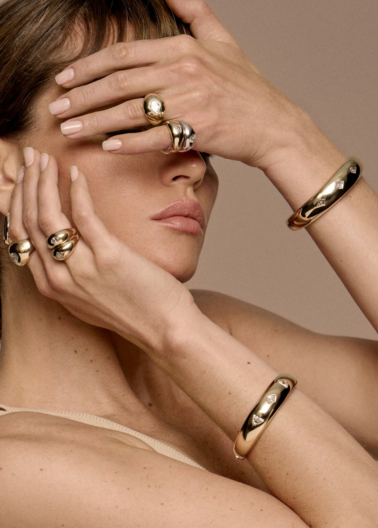 woman wearing rings and bracelets from the vrai x petra and meehan flannery collection